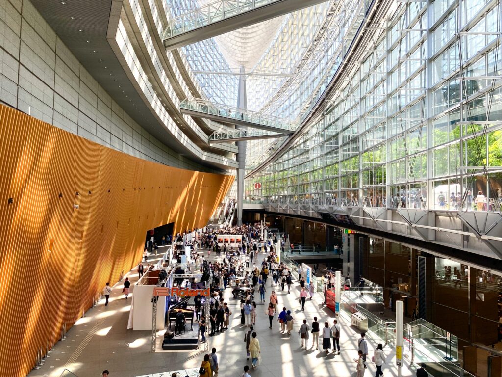 A bustling scene inside the modern architecture of Tokyo International Forum in Japan.